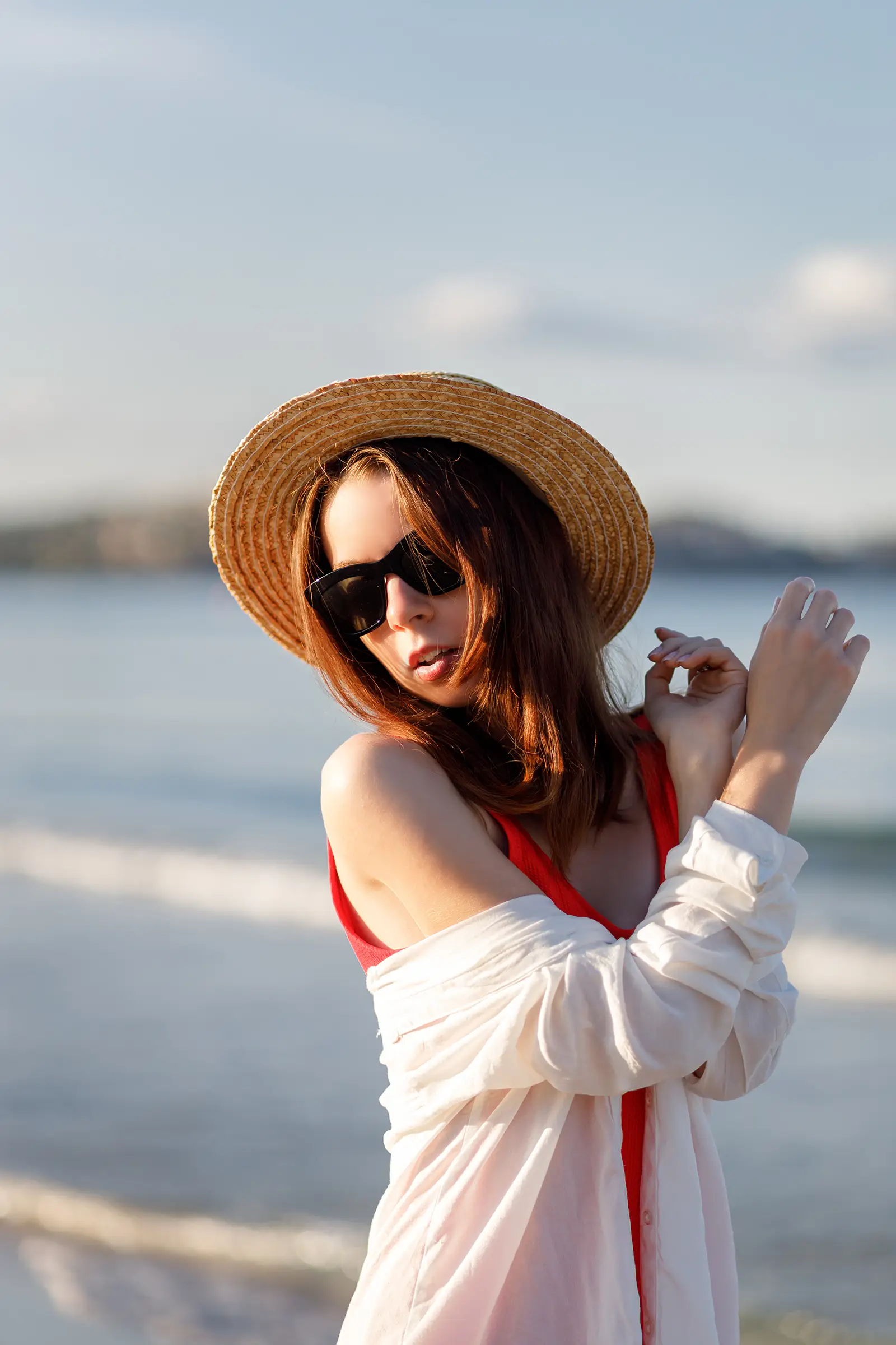 Sunny day, girl on the beach with trach hat