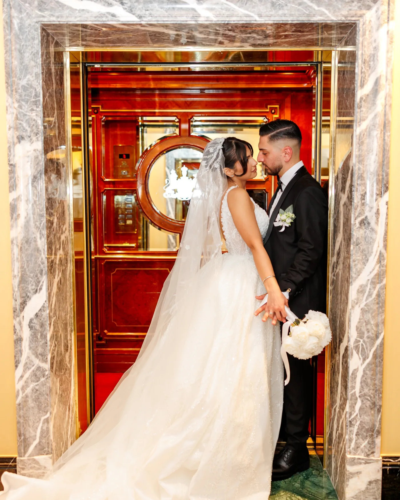 Bride and groom at an ornate red doorway in Vienna