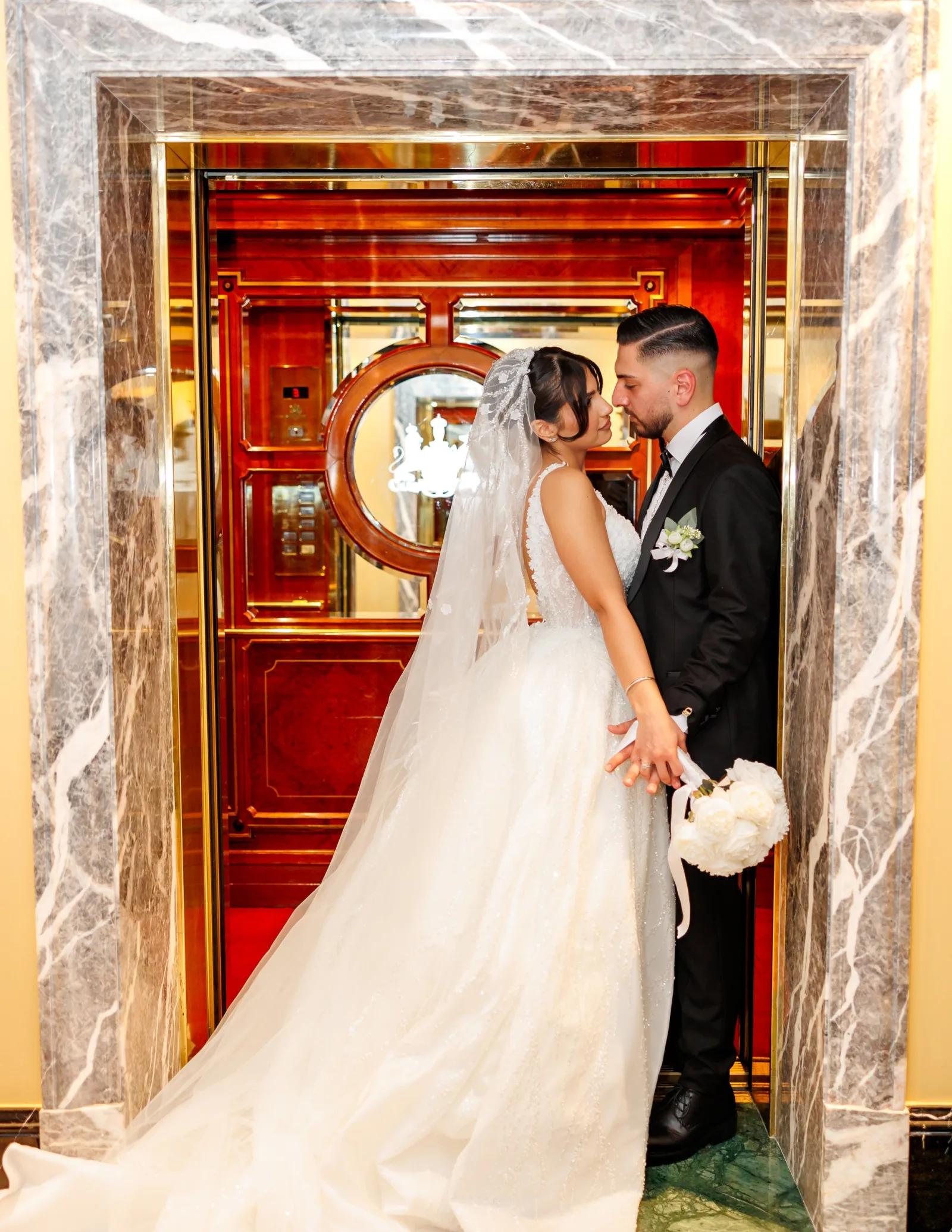 Bride and groom at an ornate red doorway in Vienna