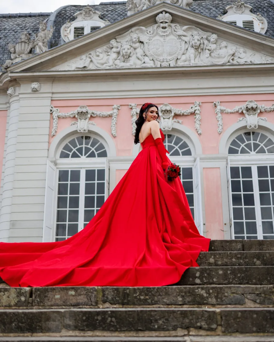 Woman in a long red gown on palace steps