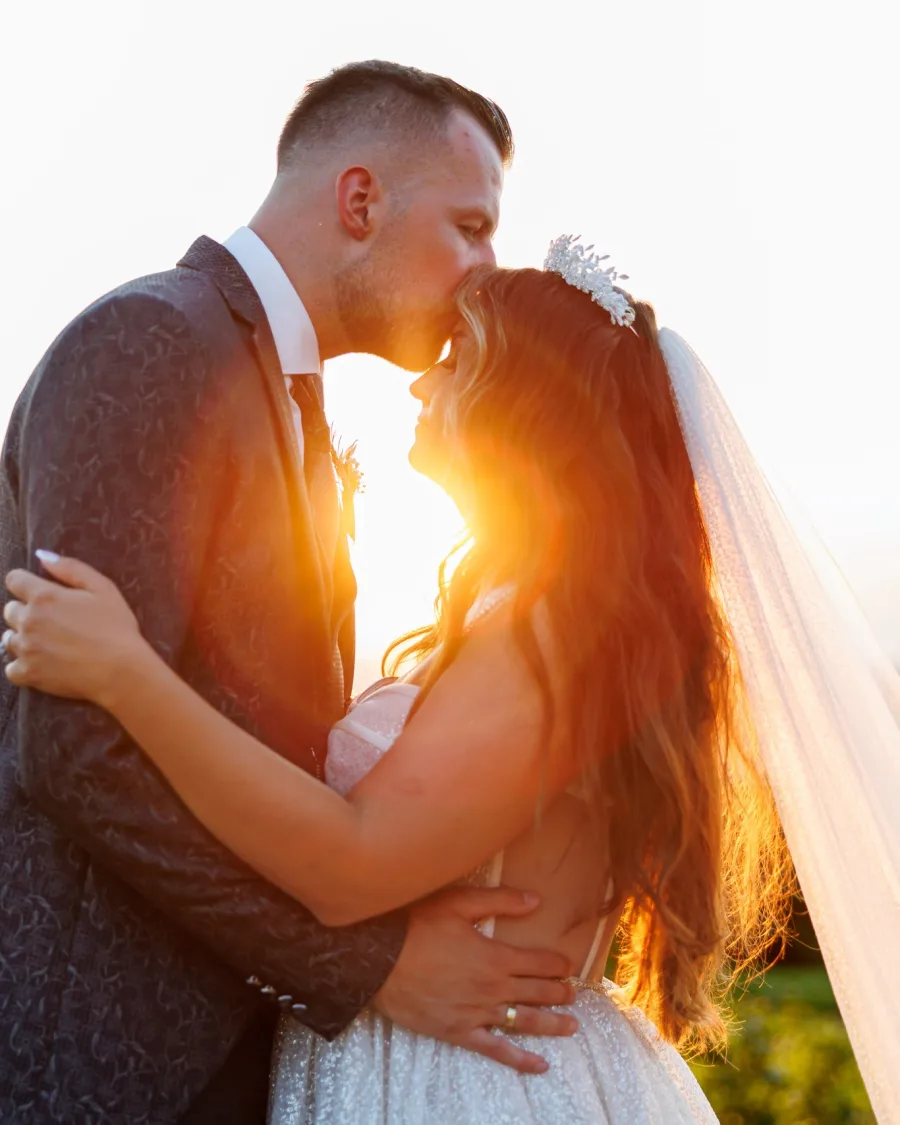 Golden hour kiss with a flowing veil